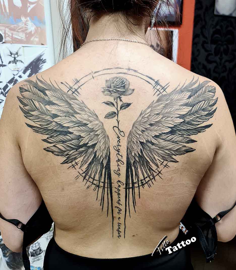 Női hát, angyal szárnyak, középen rózsa és írás a gerincen