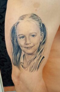 kislány portré tetoválás, fekete fehér, felkar a tilla tetováló szalonban budapest 15. kerületben